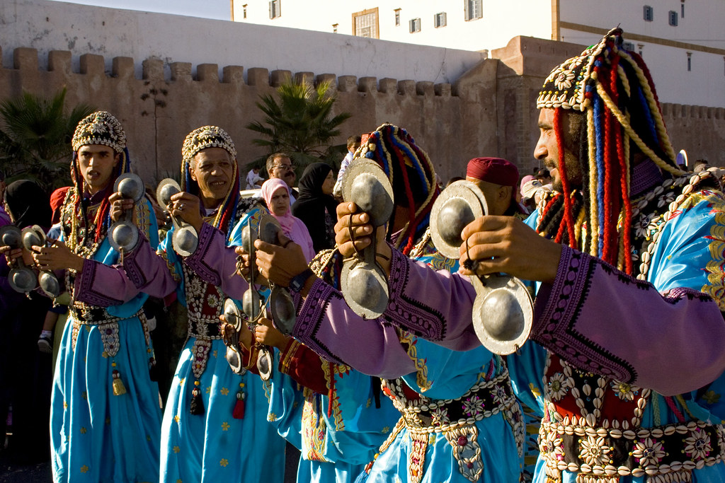 Colorful collage showcasing various Moroccan music festivals, featuring musicians performing traditional instruments, vibrant crowds enjoying the celebrations