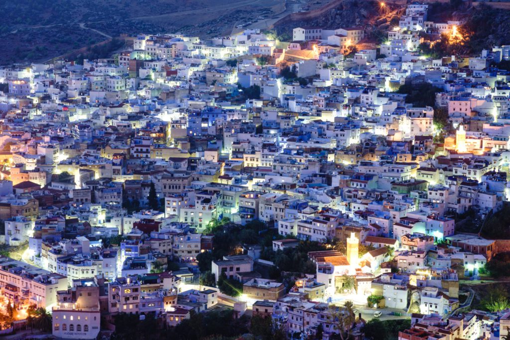 Stunning view of Chefchaouen's blue-painted buildings nestled in the Rif Mountains under a clear blue sky.