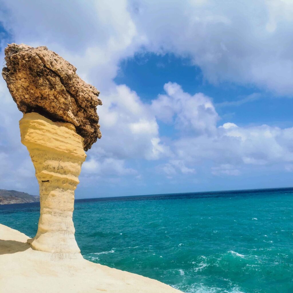 Stunning view of Carablanca Beach in Nador, featuring golden sands, clear blue waters, and lush green hills in the background.
