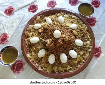An assortment of ingredients for Moroccan Rfissa, including shredded flatbread, lentils, chicken pieces, onion, garlic, turmeric, ginger, and a sprinkle of aromatic spices, arranged artfully on a wooden surface.